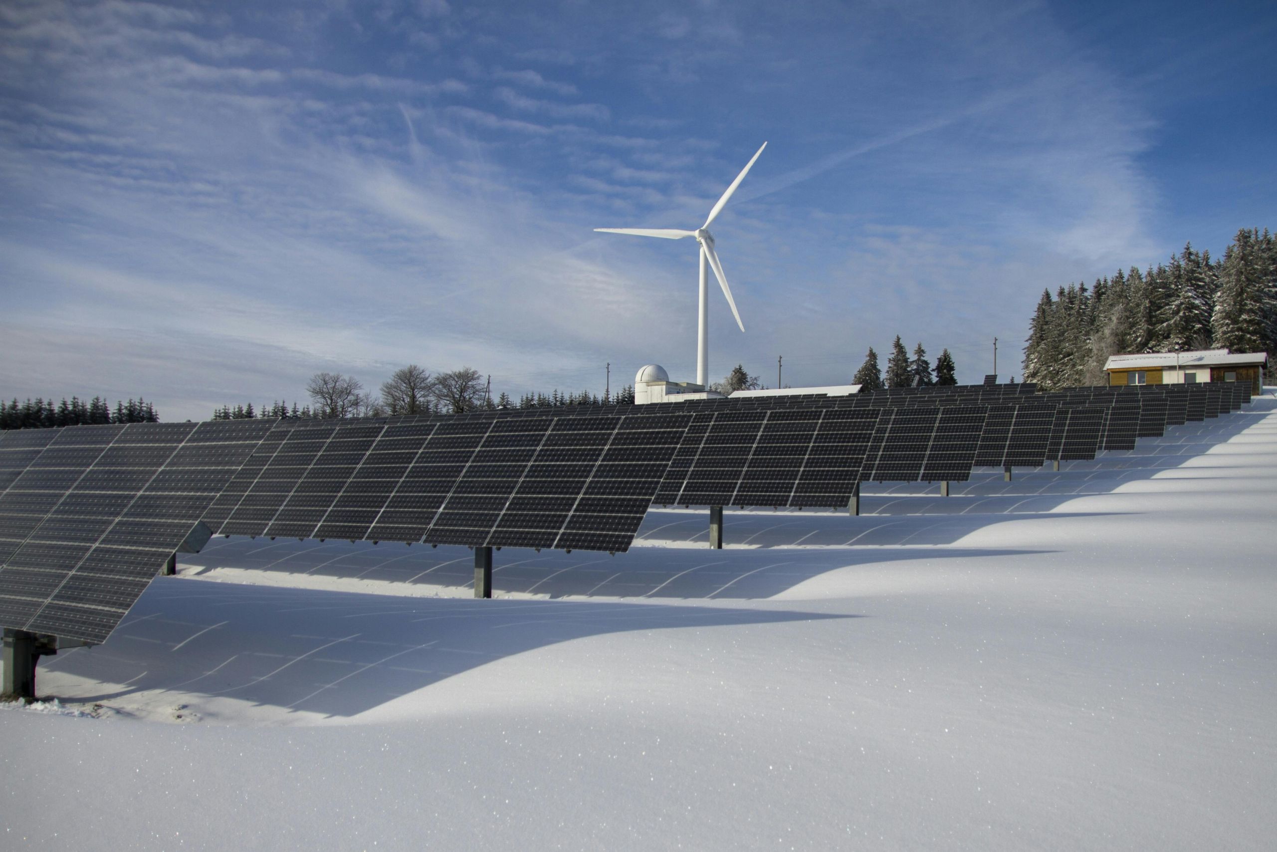 Solar panels and wind turbine generating clean energy in winter